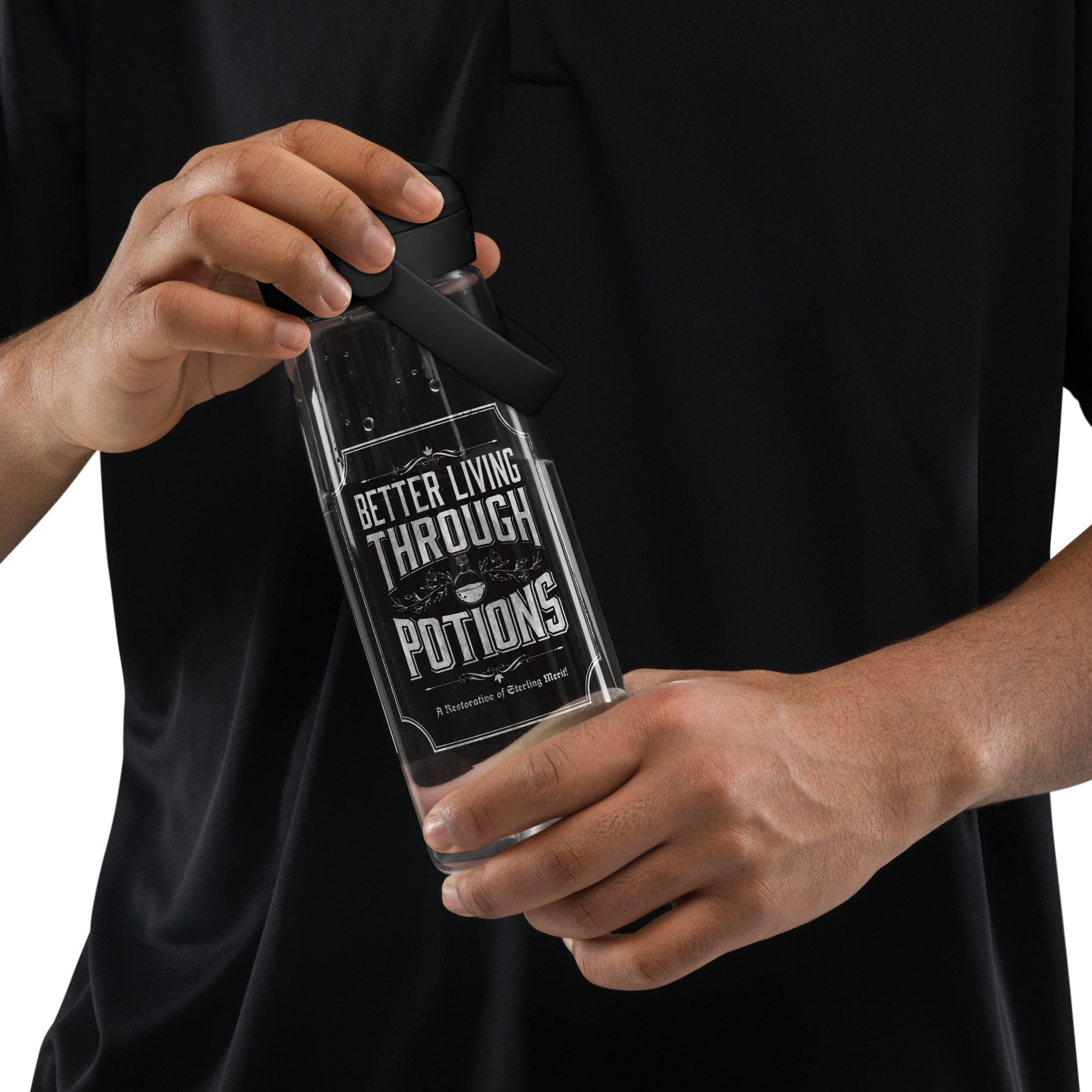 A person in a black polo shirt holds a grey plastic water bottle with a black lid. The bottle has a printed graphic that reads 'BETTER LIVING THROUGH POTTIONS' with a potion flask illustration.