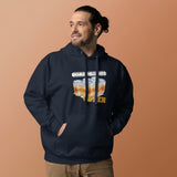 A man wearing a navy blue hoodie with a 'Boating Games' graphic on the chest, standing against a solid peach-colored background.