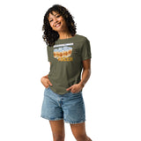 Woman with curly hair wearing green t-shirt with our board games and beer design on it