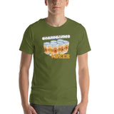 A man wearing an olive green crewneck t-shirt with a graphic print that reads 'BOARDGAMES' above an illustration of six beer cans and 'BEER' below, paired with gray jeans against a plain white background.