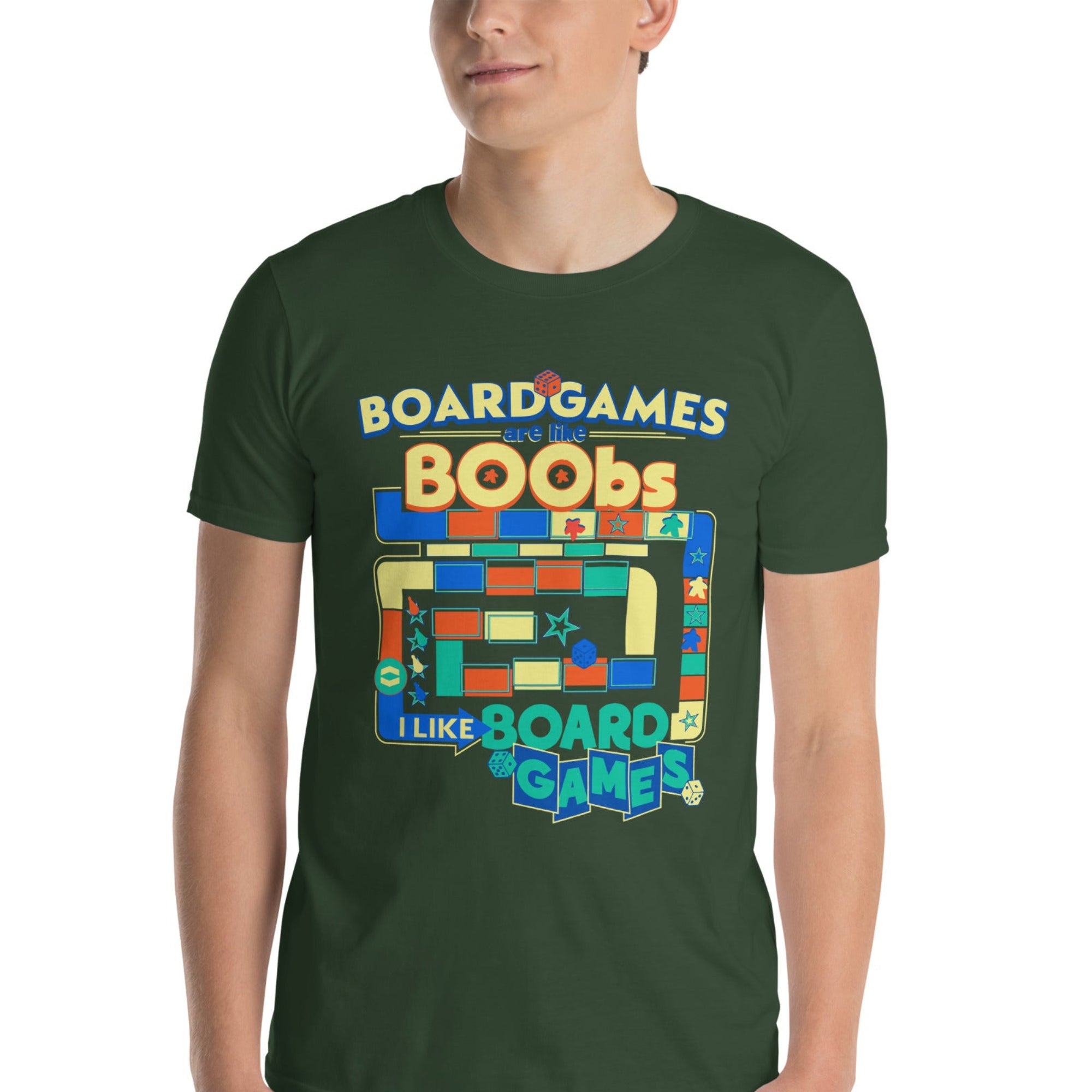 A man wearing a dark green graphic t-shirt with a colorful board game design that reads 'BOARDGAMES ARE LIKE BOOBS I LIKE BOARD GAMES'.