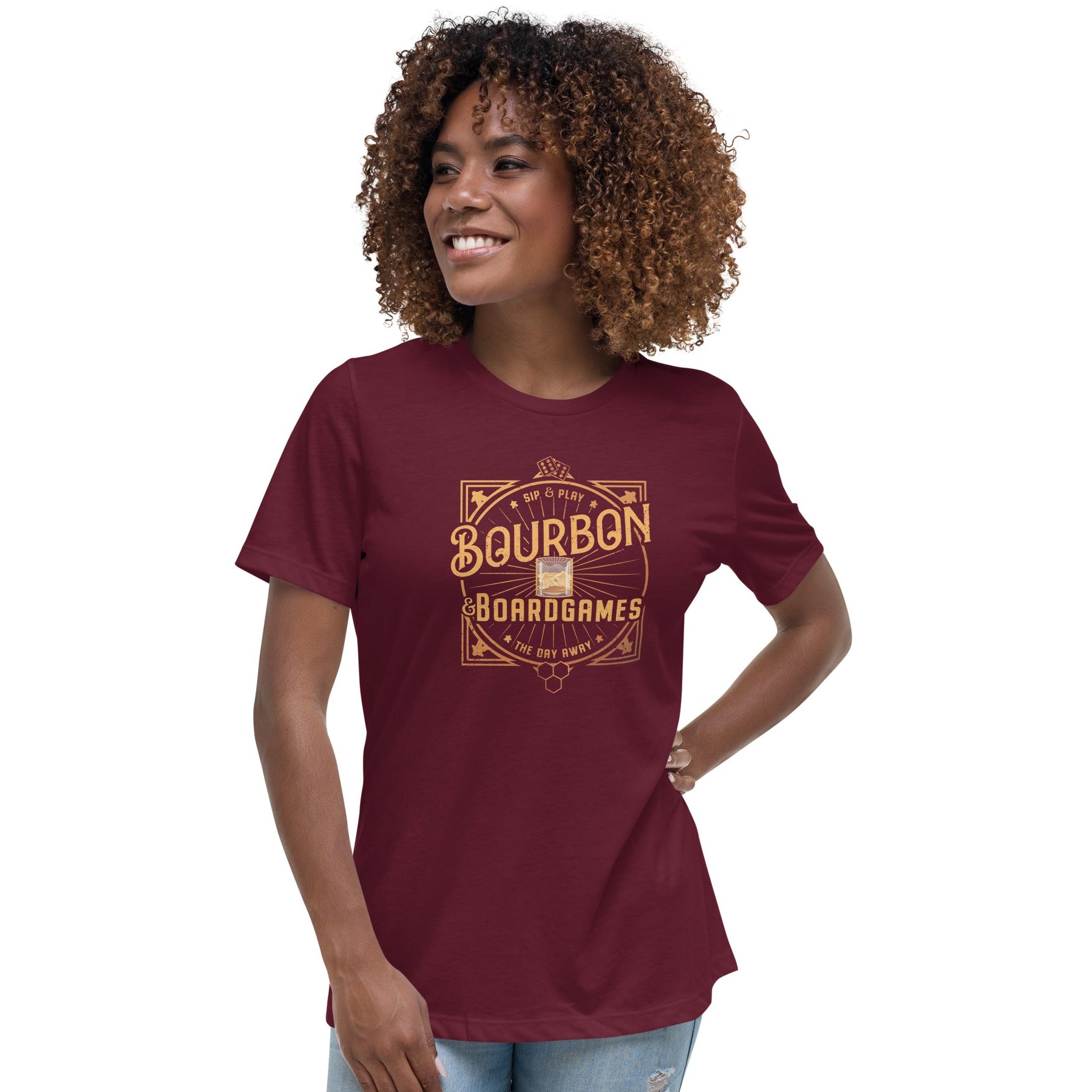 A woman wearing a red women's t-shirt with a bourbon and board games design on the front