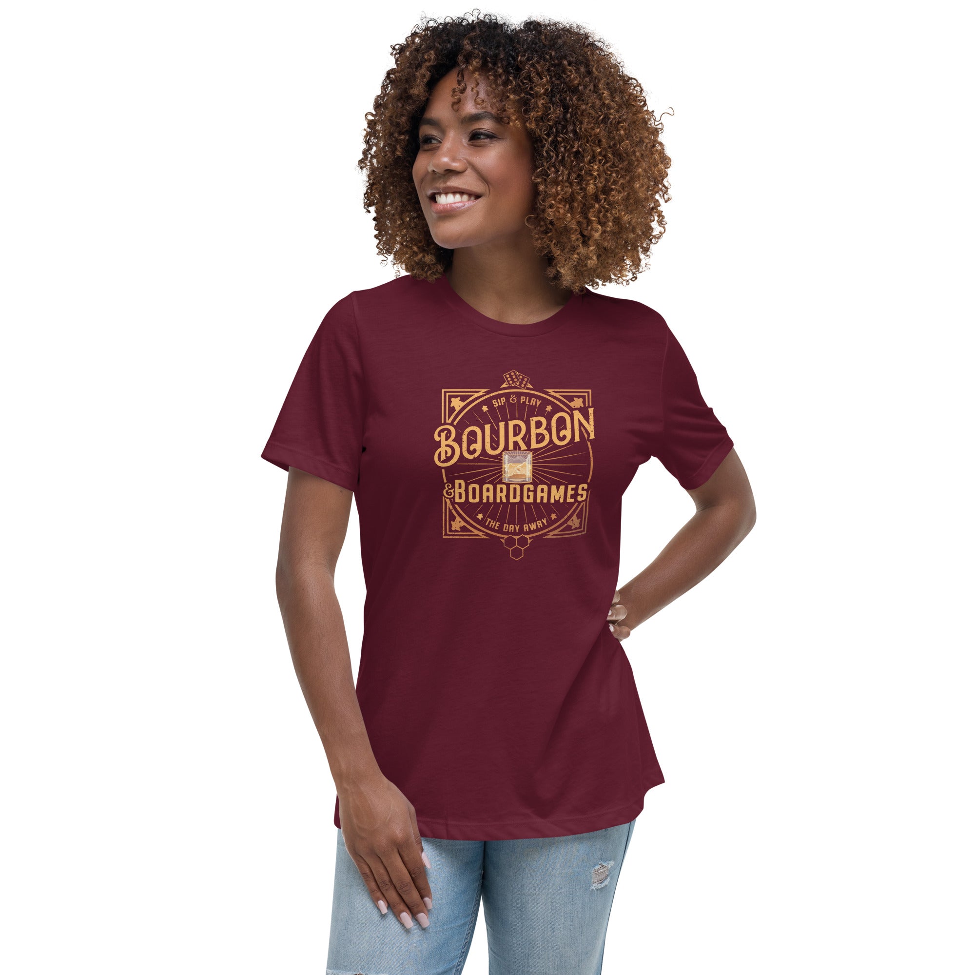 A woman wearing a red women's t-shirt with a bourbon and board games design on the front