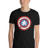 A 100% ringspun cotton t-shirt printed with a red, white, and blue shield design featuring a wooden meeple figure at its center in place of a star.