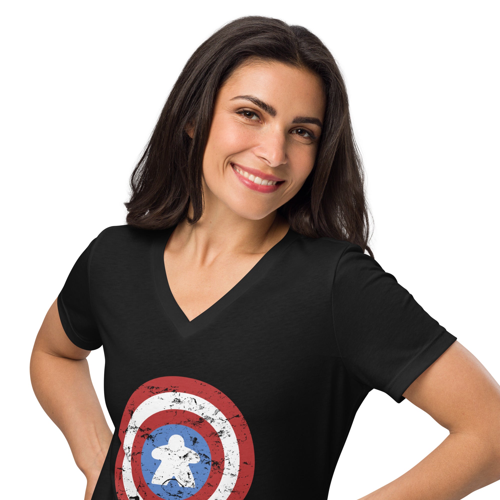 A woman with dark hair smiling and posing in a black V-neck t-shirt featuring a distressed Captain Meeple shield graphic on the front, set against a plain white background.