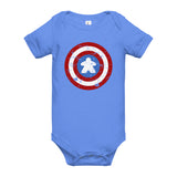A baby short-sleeve bodysuit in light blue, featuring a distressed Captain Meeple shield graphic on the chest with red, white, and blue colors.