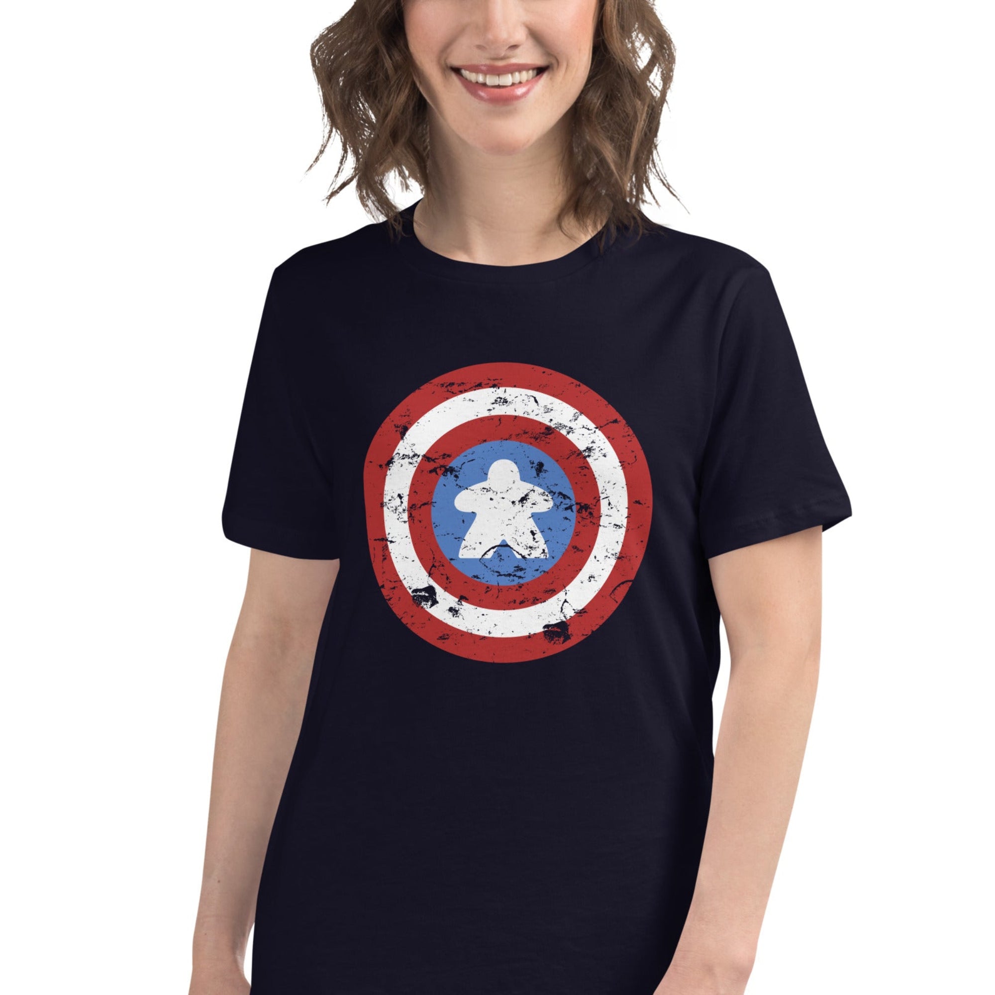 A women's fitted t-shirt in 100% ringspun cotton printed with a red, white, and blue shield design featuring a meeple at its center in place of a star.