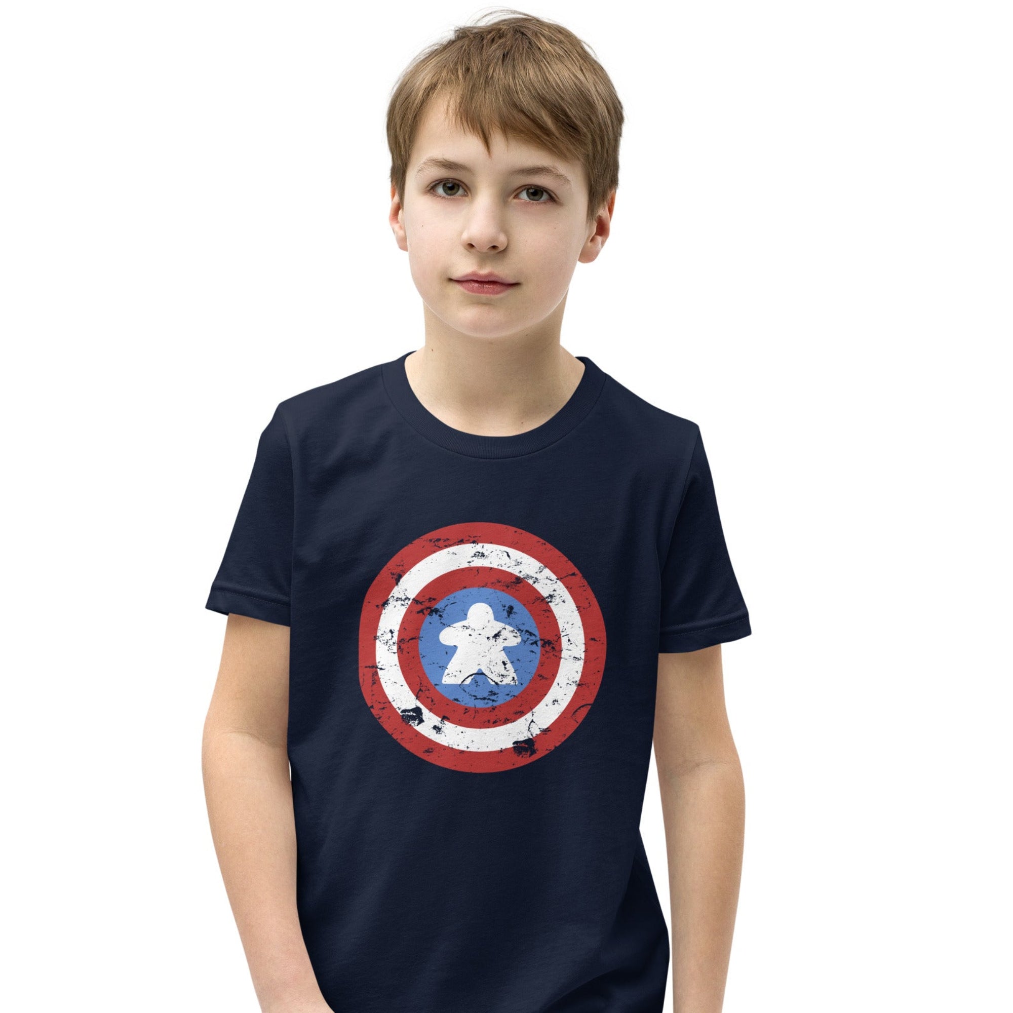 A youth-sized t-shirt printed with a red, white, and blue shield design featuring a wooden meeple at its center in place of a star.