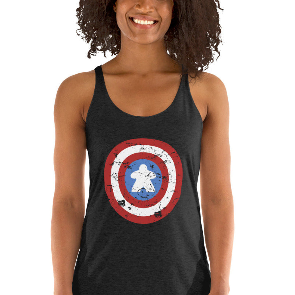 A women's racerback tank top printed with a red, white, and blue shield design featuring a white meeple at its center in place of a star.
