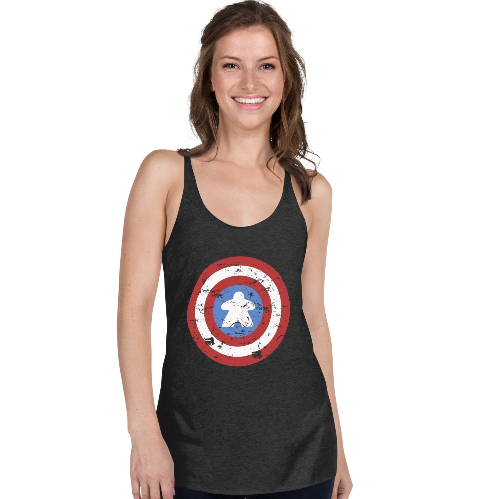 A woman modeling a vintage black racerback tank top featuring a distressed Captain Meeple shield graphic on the front with a meeple at the center instead of a star, set against a plain white background.